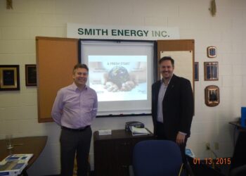 Jeff Clarke and Anthony Jonkov in front of a Smith Energy presentation.